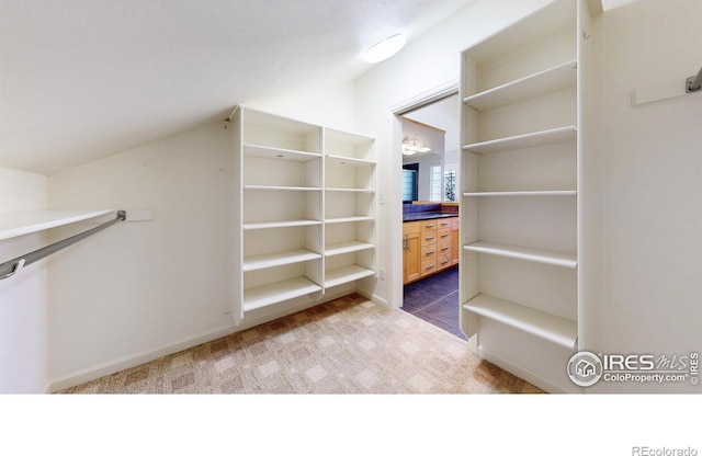 spacious closet with vaulted ceiling and carpet flooring