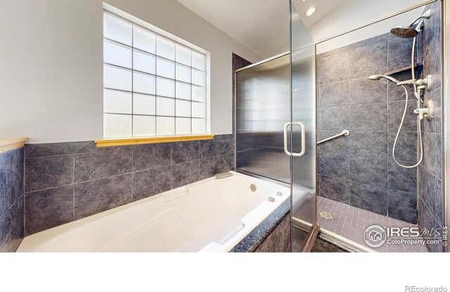 full bathroom with a bath and a stall shower