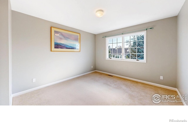 unfurnished room featuring carpet flooring, baseboards, and visible vents