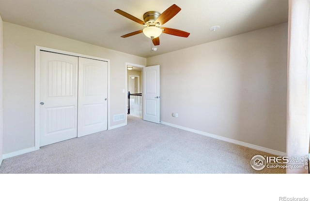 unfurnished bedroom featuring carpet floors, baseboards, visible vents, and a closet