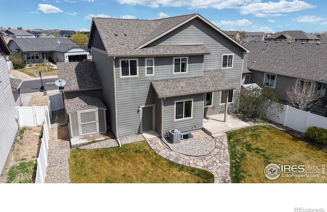 back of property featuring a fenced backyard, a patio area, a shed, and a residential view