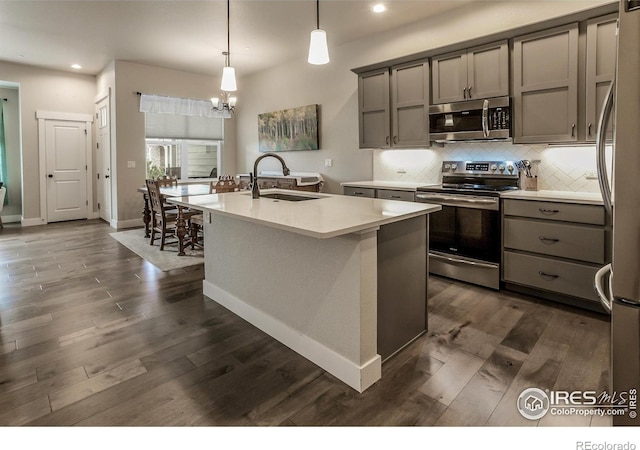 kitchen featuring gray cabinets, dark wood-style flooring, appliances with stainless steel finishes, a sink, and recessed lighting