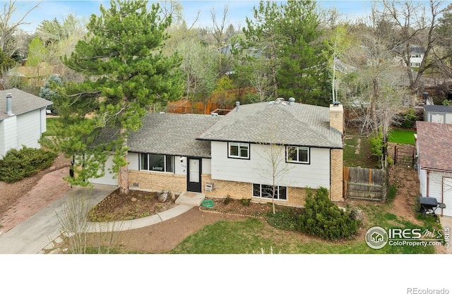 1208 Briarwood Rd, Fort Collins, CO 80521 - split level home with brick siding, a chimney, a shingled roof, and driveway