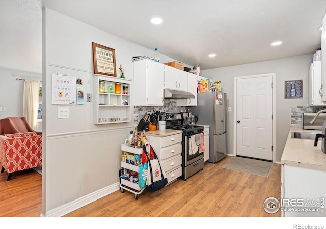 1208 Briarwood Rd, Fort Collins, CO 80521 - kitchen featuring stainless steel appliances, under cabinet range hood, light countertops, white cabinets, and light wood finished floors
