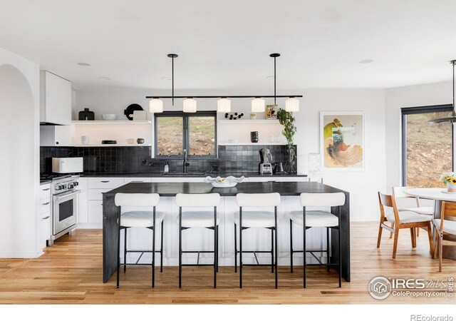 319 S Peak Rd, Boulder, CO 80302 - kitchen with open shelves, dark countertops, white cabinetry, high end stove, and a sink