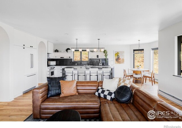 319 S Peak Rd, Boulder, CO 80302 - living area with light wood-style floors, arched walkways, and a baseboard heating unit