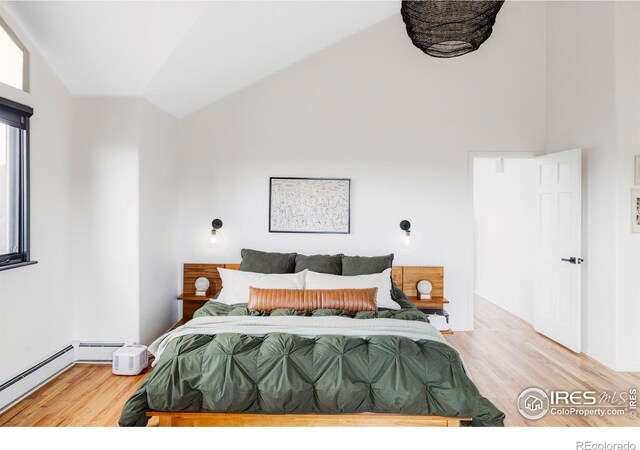 319 S Peak Rd, Boulder, CO 80302 - bedroom featuring light wood-style flooring, baseboard heating, and high vaulted ceiling