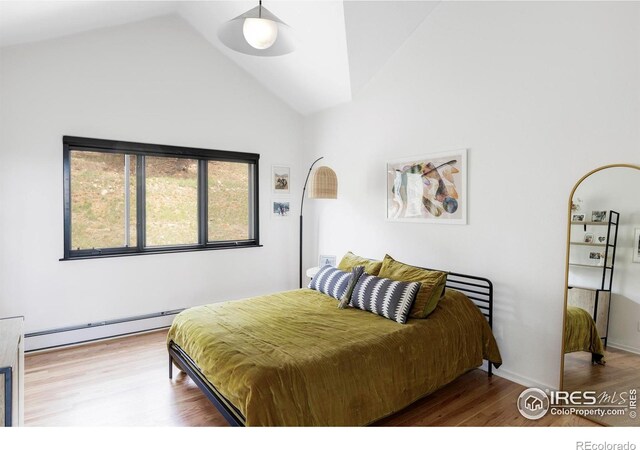 319 S Peak Rd, Boulder, CO 80302 - bedroom featuring wood finished floors, a baseboard heating unit, and vaulted ceiling