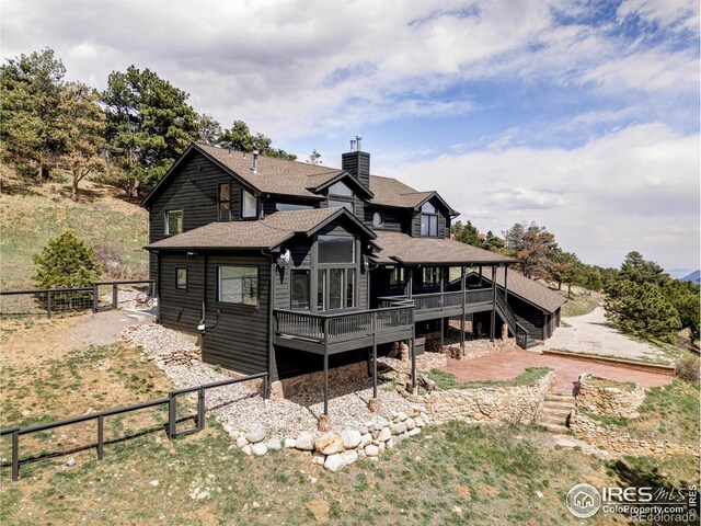 319 S Peak Rd, Boulder, CO 80302 - rear view of property with roof with shingles, stairs, a deck, a fenced backyard, and a chimney