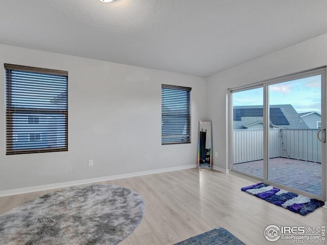 unfurnished room with baseboards and wood finished floors
