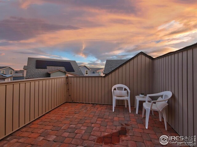 patio terrace at dusk with a fenced backyard