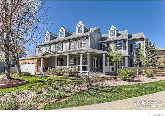 view of front of home featuring fence, covered porch, and an attached garage