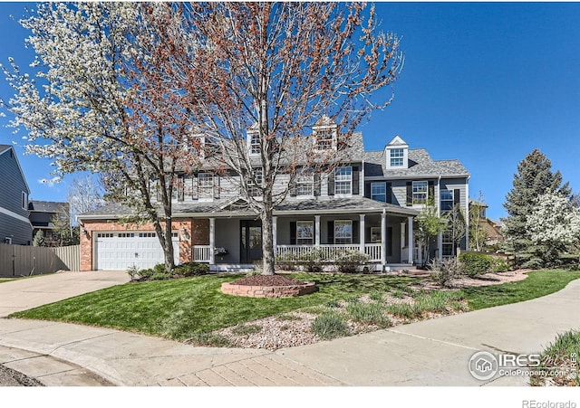 view of front of home featuring fence, covered porch, a front yard, concrete driveway, and an attached garage
