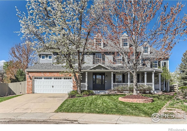 view of front of property featuring an attached garage, fence, a front yard, concrete driveway, and a porch