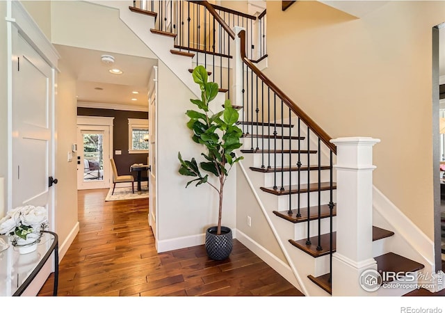 staircase featuring crown molding, baseboards, recessed lighting, and wood finished floors