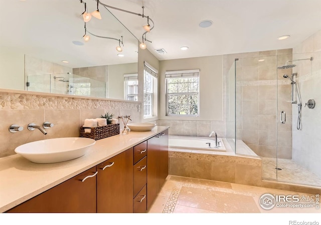 full bath with a shower stall, a sink, and a garden tub