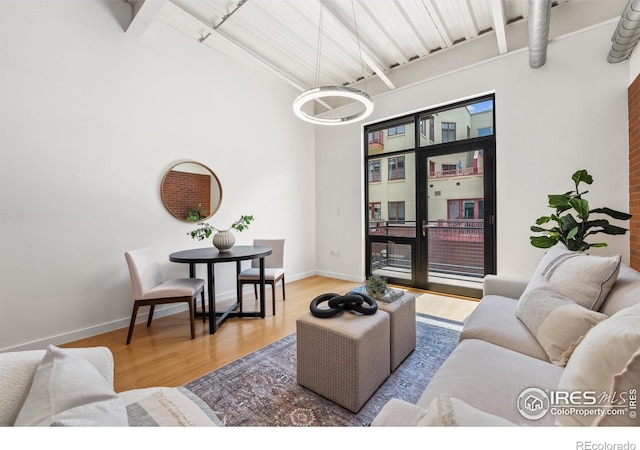 1360 Walnut St Unit 211, Boulder, CO 80302 - living area with wood finished floors, baseboards, a towering ceiling, and beam ceiling