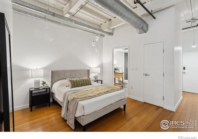 1360 Walnut St Unit 211, Boulder, CO 80302 - bedroom with baseboards, hardwood / wood-style floors, and a towering ceiling
