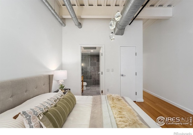 1360 Walnut St Unit 211, Boulder, CO 80302 - bedroom with baseboards, wood finished floors, ensuite bathroom, and a towering ceiling