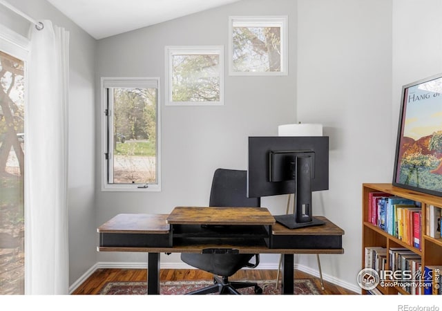 office area with wood finished floors, baseboards, plenty of natural light, and vaulted ceiling