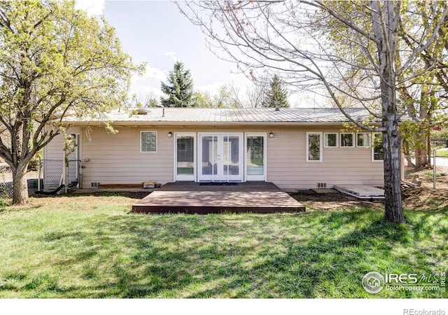 rear view of house featuring a wooden deck, french doors, and metal roof