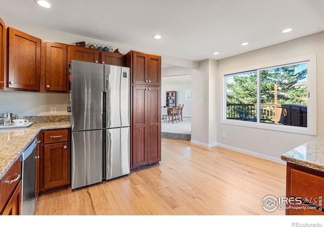 319 Camino Bosque, Boulder, CO 80302 - kitchen featuring appliances with stainless steel finishes, light wood-style floors, recessed lighting, light stone counters, and baseboards