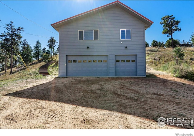 319 Camino Bosque, Boulder, CO 80302 - view of property exterior with dirt driveway and an attached garage
