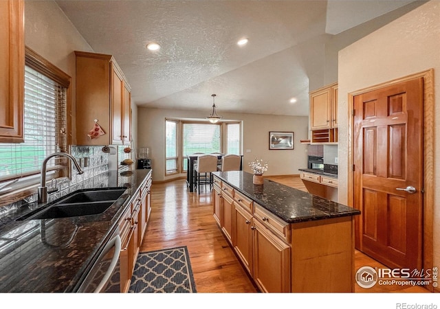 11669 Montgomery Cir, Longmont, CO 80504 - kitchen with backsplash, a sink, light wood finished floors, and dishwasher