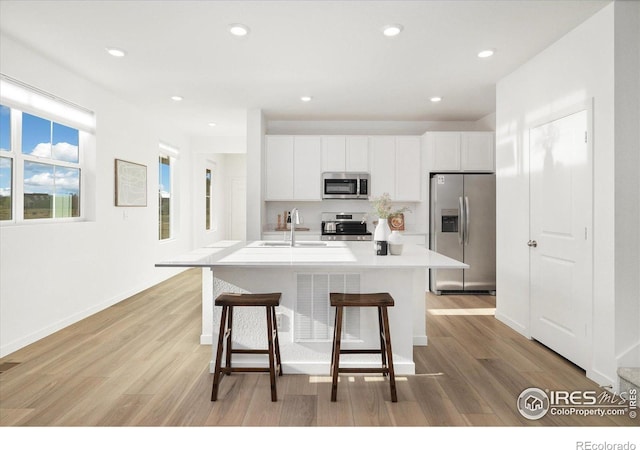 2260 Crescent Cir, Erie, CO 80026 - kitchen with appliances with stainless steel finishes, a sink, light wood-style floors, white cabinets, and recessed lighting