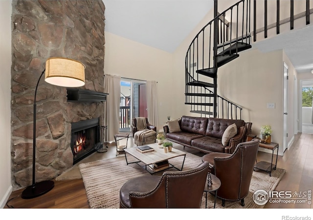 6385 Oak St Unit 301, Arvada, CO 80004 - living area featuring high vaulted ceiling, wood finished floors, stairs, and a stone fireplace