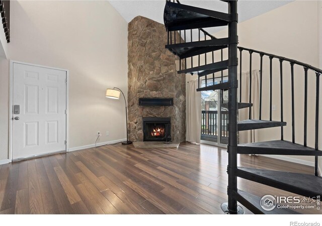6385 Oak St Unit 301, Arvada, CO 80004 - unfurnished living room featuring high vaulted ceiling, wood finished floors, and a fireplace
