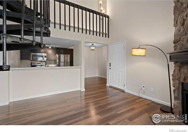 6385 Oak St Unit 301, Arvada, CO 80004 - unfurnished living room with wood finished floors, a high ceiling, and a stone fireplace