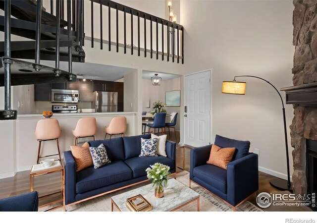 6385 Oak St Unit 301, Arvada, CO 80004 - living area with wood finished floors, a towering ceiling, and a stone fireplace