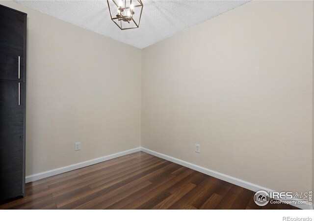6385 Oak St Unit 301, Arvada, CO 80004 - unfurnished room featuring dark wood-type flooring, a chandelier, and a textured ceiling