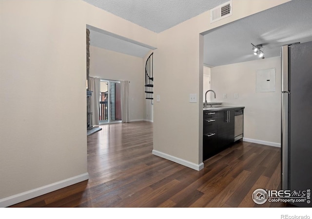 6385 Oak St Unit 301, Arvada, CO 80004 - kitchen with stainless steel appliances, dark wood finished floors, a textured ceiling, dark cabinets, and light countertops