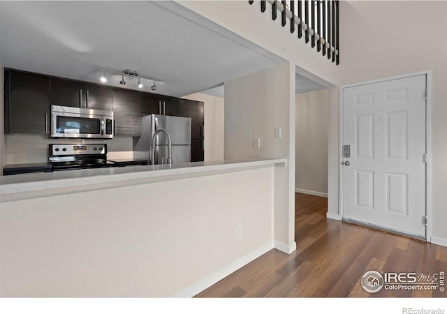 6385 Oak St Unit 301, Arvada, CO 80004 - kitchen featuring stainless steel appliances, dark wood-style flooring, light countertops, modern cabinets, and dark cabinets