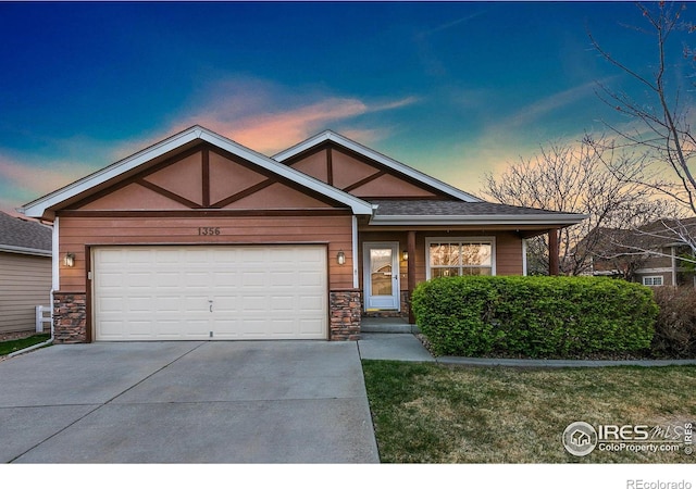 1356 Boardwalk Dr, Windsor, CO 80550 - view of front facade featuring driveway, a garage, and stone siding