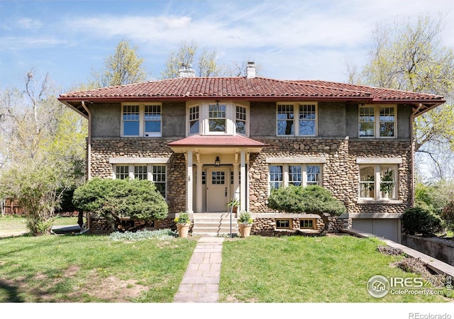 view of front of house with a chimney, a garage, a front lawn, stone siding, and stucco siding