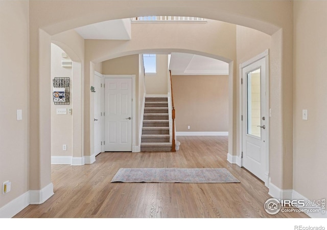3530 Willow Rd, Frederick, CO 80504 - foyer featuring stairs, arched walkways, baseboards, and wood finished floors