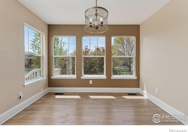 3530 Willow Rd, Frederick, CO 80504 - unfurnished dining area featuring baseboards, wood finished floors, and a chandelier