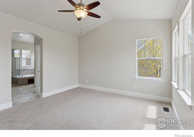 3530 Willow Rd, Frederick, CO 80504 - carpeted spare room featuring visible vents, baseboards, ceiling fan, arched walkways, and vaulted ceiling