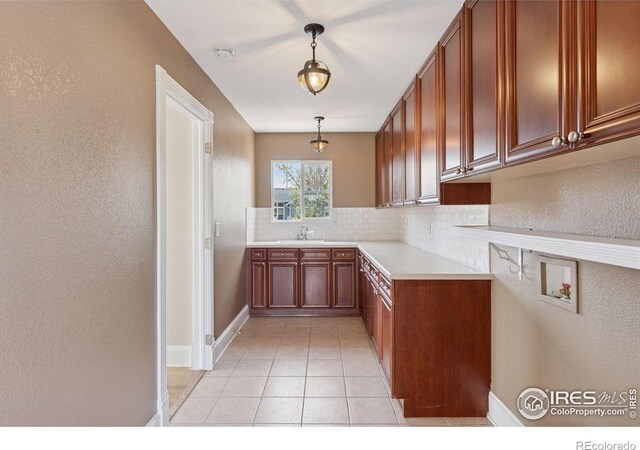 3530 Willow Rd, Frederick, CO 80504 - kitchen featuring a textured wall, a sink, light countertops, backsplash, and pendant lighting