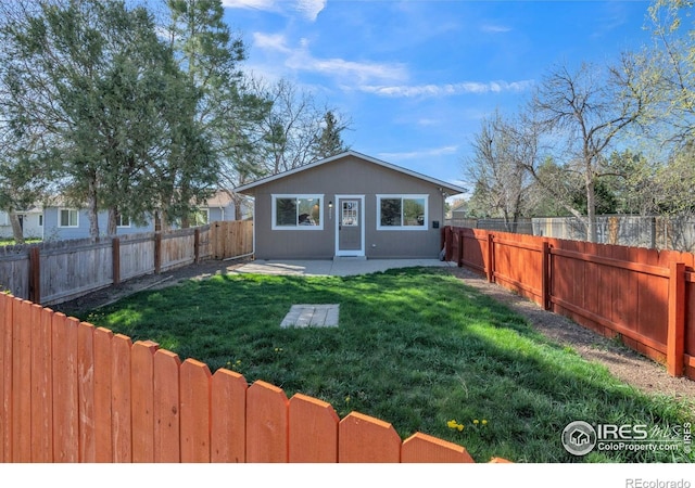 back of house featuring a lawn, a fenced backyard, and a patio area