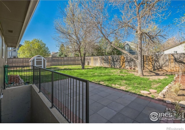 view of patio / terrace featuring a storage unit, a fenced backyard, and an outdoor structure