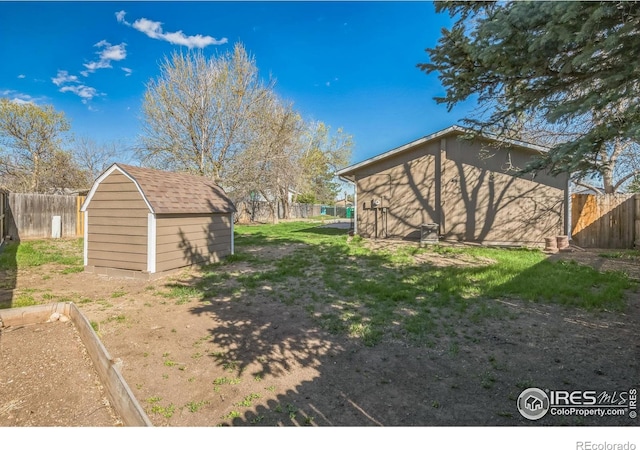 view of yard featuring a fenced backyard, an outdoor structure, and a shed