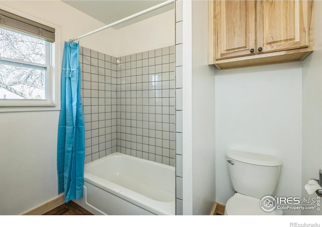 bathroom featuring baseboards, shower / bath combination with curtain, and toilet