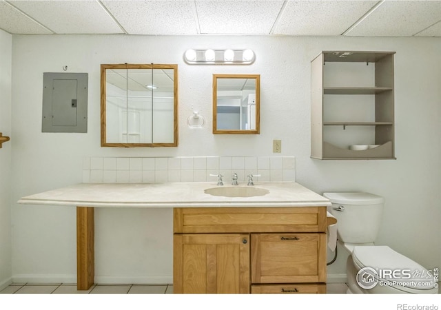 bathroom with vanity, toilet, a paneled ceiling, backsplash, and electric panel