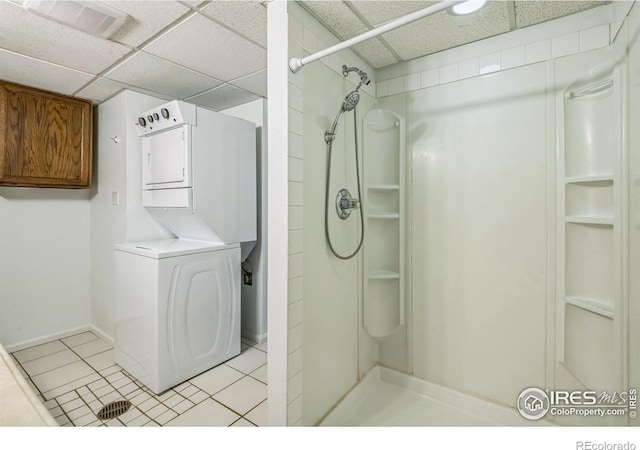 bathroom featuring stacked washing maching and dryer, visible vents, a shower, and a paneled ceiling