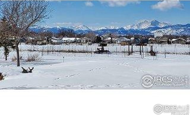 yard layered in snow featuring a mountain view