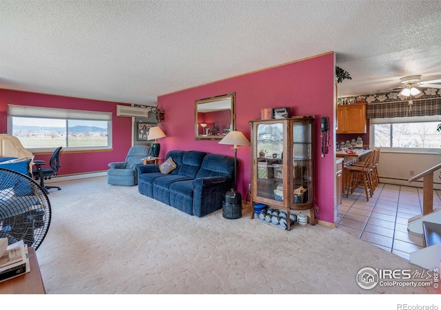 carpeted living area with a textured ceiling, baseboards, a wall unit AC, and a ceiling fan